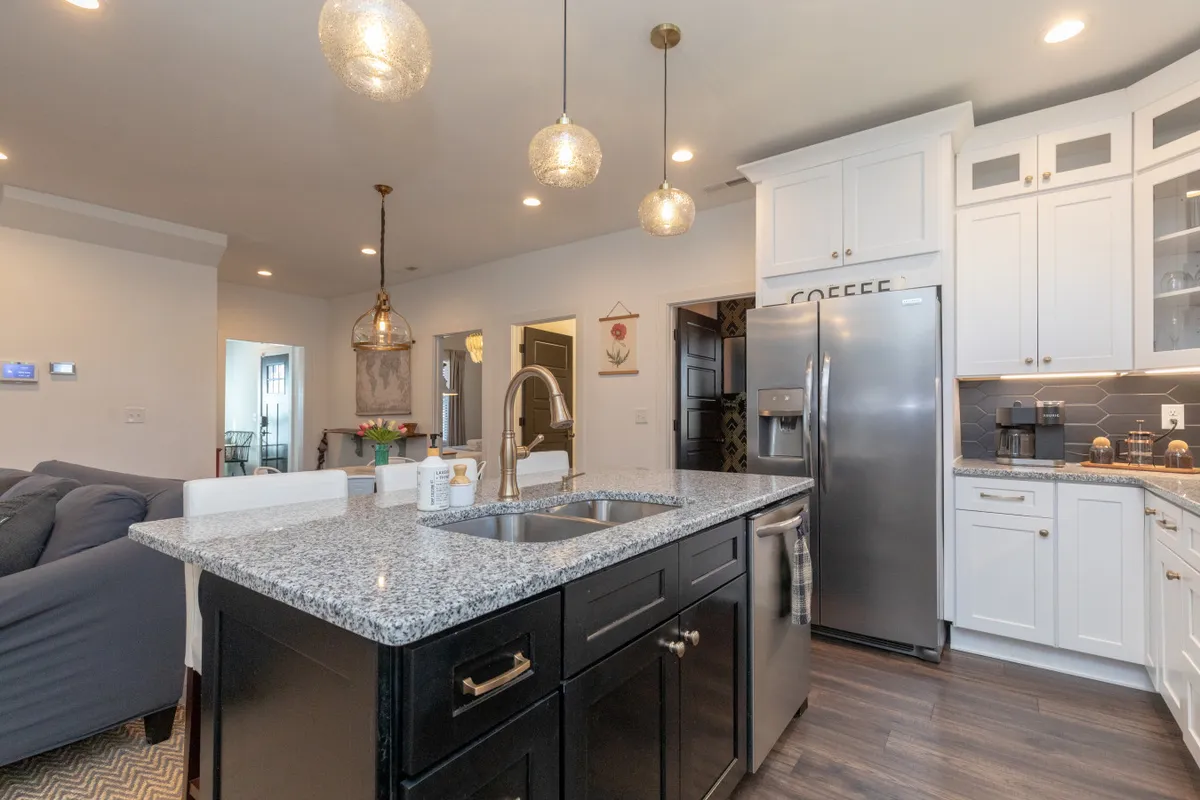 A bright, modern kitchen with a central island, pendant lighting, and stainless steel appliances. The space is ideal for cooking, entertaining, and morning coffee rituals, with enough room for groups to gather and mingle.